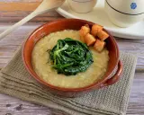 Piatto di fave e cicoria, una crema gialla con verdura verde al centro e crostini dorati.
