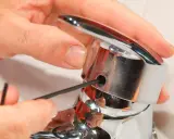 Mano ajustando un grifo monomando con llave Allen. Así es como funciona un grifo monomando.