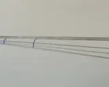 Szkic przedstawia elementy wędki, w tym uchwyt kołowrotka i linię wskazującą oś kołowrotka. Widoczne są też linie symbolizujące żyłkę pod bardzo małymi kątami.
