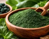 Zielony proszek spiruliny w drewnianej misce, obok tabletek, cytryny, jagód i awokado. To jest spirulina, co to za superfood?