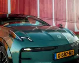 El elegante Zeekr X, un coche eléctrico verde oscuro, se exhibe con su distintivo logo y faros LED, listo para la aventura.