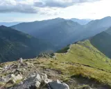 Widok na pasmo górskie Tatr z zielonymi zboczami i kamienistym szlakiem.