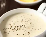 Sauce béchamel onctueuse, préparée avec de la fécule de maïs et assaisonnée de poivre noir fraîchement moulu.
