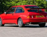 Roter Ford Sierra RS Cosworth mit großem Heckspoiler und markanten Felgen, bereit für die nächste Ausfahrt.