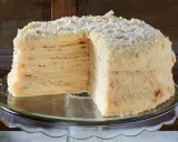 Ein aufgeschnittener Napoleon Kuchen mit vielen dünnen Schichten und cremiger Füllung, bestreut mit Krümeln.