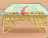 Un modelo de puentes de madera se construye sobre un plano de ingeniería.