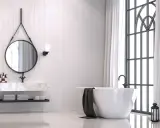 Elegancka oprawa łazienkowa z wolnostojącą wanną, okrągłym lustrem i marmurowym blatem.