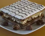 Un délicieux fondant millefeuille, garni de crème pâtissière et décoré de glaçage blanc et chocolat, est présenté sur une assiette avec quelques marrons glacés.