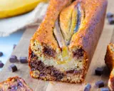 Un délicieux banana bread healthy, garni de pépites de chocolat, avec des bananes entières sur le dessus.