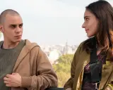 Due giovani si guardano intensamente, come se fossero in una "casa degli sguardi". Lui, rasato, lei con lunghi capelli castani.