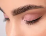 Ojo cerrado con sombra rosa y delineado fino, mostrando diferentes tipos de raya del ojo.