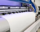 Profesjonalna maszyna do druku na folii transferowej przygotowuje materiał do nadruku.