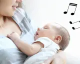 Mama śpiewa kołysankę dla dziecka, które zasypia w jej ramionach. Nutki unoszą się w powietrzu, tworząc magiczną atmosferę.