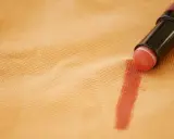 Rossetto su tessuto color pesca, un esempio pratico su come togliere il fondotinta dai vestiti.