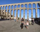 Familia pasea bajo el Acueducto de Segovia, un lugar ideal que ver en Segovia con niños.