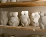 Plusieurs torses féminins en argile, une idée sculpture argile facile pour débutants, alignés sur une étagère.