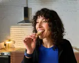 Frau isst einen Riegel, die perfekte Energie für das, was essen vor dem Training.