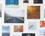 Un collage di fotografie su una parete bianca: paesaggi, ritratti, natura. Un'idea su come esporre fotografie in modo creativo.