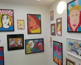 Bunte Pop-Art-Bilder, entstanden im Kunstunterricht, zieren die Wand. Porträts von Frauen im Comic-Stil, kräftige Farben und Linien.