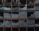 Estanterías llenas de perfiles metálicos, tubos redondos y cuadrados, listos para ser transformados en estructuras.