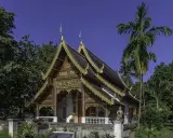 Złocone zdobienia świątyni w Chiang Mai, otoczonej bujną zielenią, to jedna z pięknych atrakcji miasta.