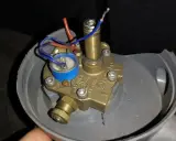 Uszkodzony elektrozawór LPG. Widoczne luźne przewody i korozja, potencjalne objawy awarii.