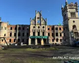 Ruiny pałacu w Kopicach, zniszczony zamek z ceglanymi ścianami i pustymi oknami, pod błękitnym niebem.
