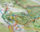 Mapa turystyczna z zaznaczonym szlakiem czerwonym, który oznacza najdłuższą trasę. Widoczne nazwy miejscowości i terenów.