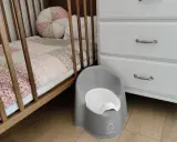 Szara nocniczka BabyBjörn obok łóżeczka. Czas na rozwiązanie problemu z odpieluchowaniem 3 latka.