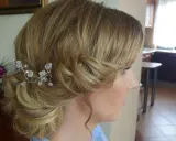 Eleganckie fryzury ślubne dla cienkich włosów: delikatny kok z kryształową ozdobą.