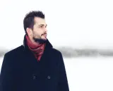 Mężczyzna w granatowym płaszczu i bordowym szaliku z wzorem. Idealne połączenie, by zadać sobie pytanie: jaki szalik do granatowego płaszcza?