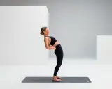 Frau dehnt den iliopsoas in einer Rückbeuge auf einer Matte.