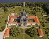 Litwa atrakcje: imponujący klasztor z kopułą i wieżą, otoczony zielenią i ogrodem, nad brzegiem jeziora.