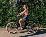 Kobieta na rowerze elektrycznym. Zastanawiasz się, ile waży rower elektryczny? Ten model jest lekki i zwinny.