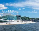 Ein sonniger Tag für Oslo Sightseeing am Opernhaus mit seiner einzigartigen Architektur und dem Wasser.