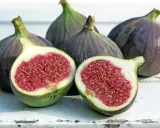 Frische Feigen, eine aufgeschnitten, zeigen ihr saftiges Inneres. Sie sind feigen gesund und ein Genuss.