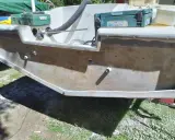 Préparation pour refaire le tableau arrière d'un bateau. Des outils et des matériaux sont visibles.
