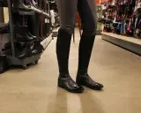 Schwarze, glänzende Reitstiefel angezogen, bereit für den Stall.