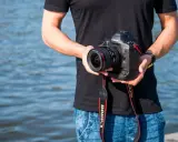 Mężczyzna trzyma aparat Canon EOS-1D Mark II z obiektywem, idealny do fotografii krajobrazowej dzięki matrycy **APS-C**.