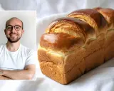 Un homme souriant à côté d'une brioche dorée. La cuisson de cette brioche, avec ou sans chaleur tournante, a donné un résultat parfait.