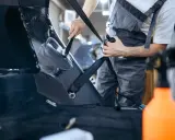 Ręczne polerowanie plastiku w bagażniku samochodu. Czystość i blask dzięki starannej pracy.