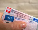Dłoń trzyma polski dowód osobisty i prawo jazdy. Czas na wymianę prawa jazdy bezterminowego?