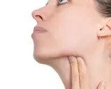 Donna si tocca il collo, preoccupata per possibili linfonodi tumore.