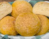 Koszyk pełen pysznych, złotych bułek bez drożdży, posypanych sezamem. Idealne na burgery lub jako dodatek do posiłku.