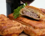 Pâté en croûte, une spécialité lorraine savoureuse, garni de viande et d'herbes, prêt à être dégusté avec un verre de vin.