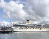 Grandi navi da crociera attraccate al terminal crociere La Spezia, con gru portuali sullo sfondo e un cielo nuvoloso.