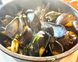 Un plat fumant de moules, prêtes à être dégustées. Un accompagnement moules parfait pour un repas savoureux.