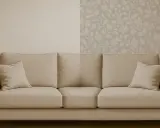 Sofá beige frente a pared dividida: un lado con textura rugosa, el otro con papel pintado floral. Se puede poner papel pintado sobre gotelé.