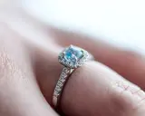 Un anello di fidanzamento con un acquamarina centrale e diamanti, simbolo di un amore eterno e profondo.