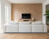 Sofá blanco modular frente a pared de ladrillo y mueble de TV. La **dirección de obra** supervisó este moderno y acogedor salón.